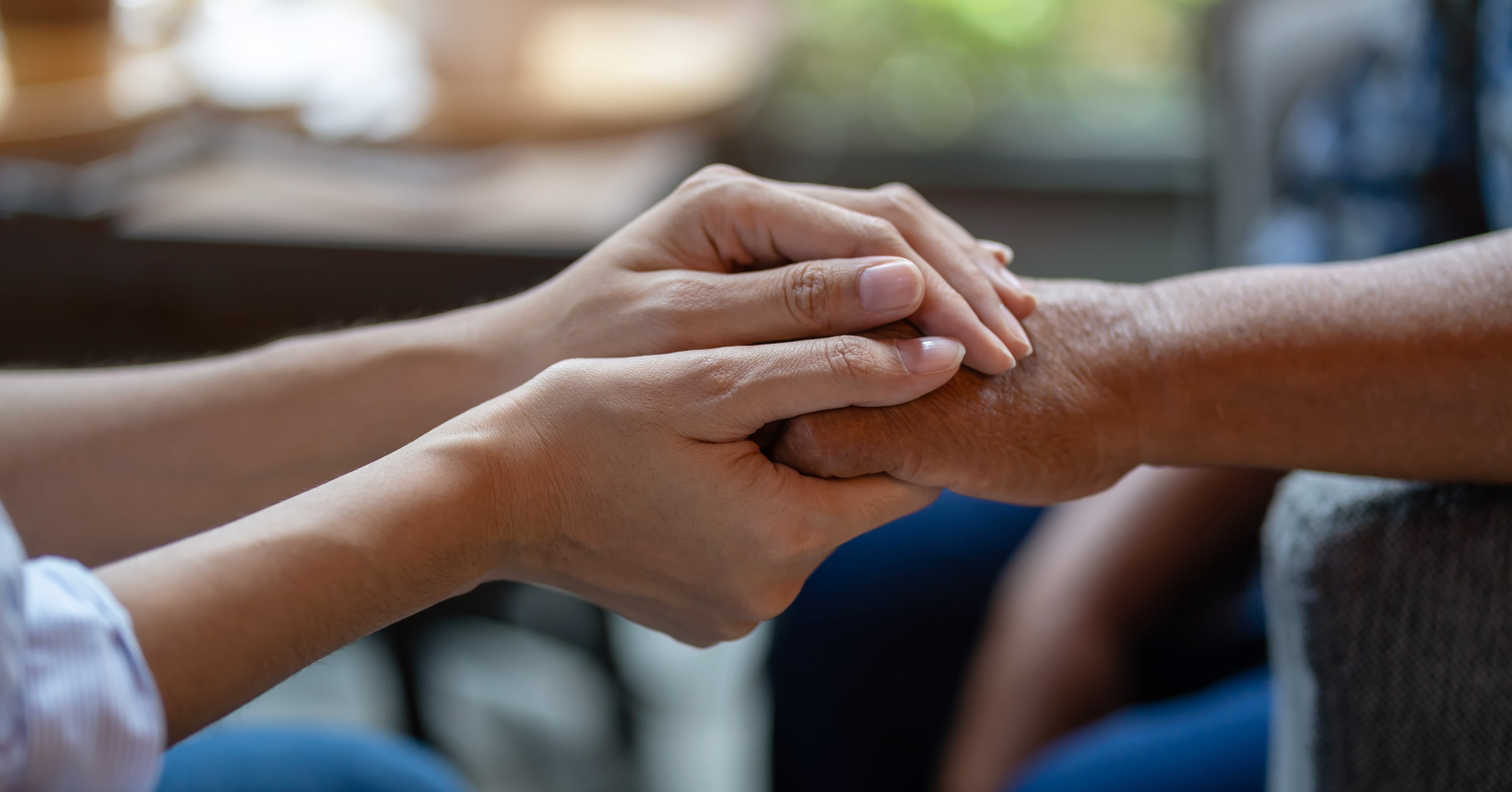 two people holding hands, representing caretaking