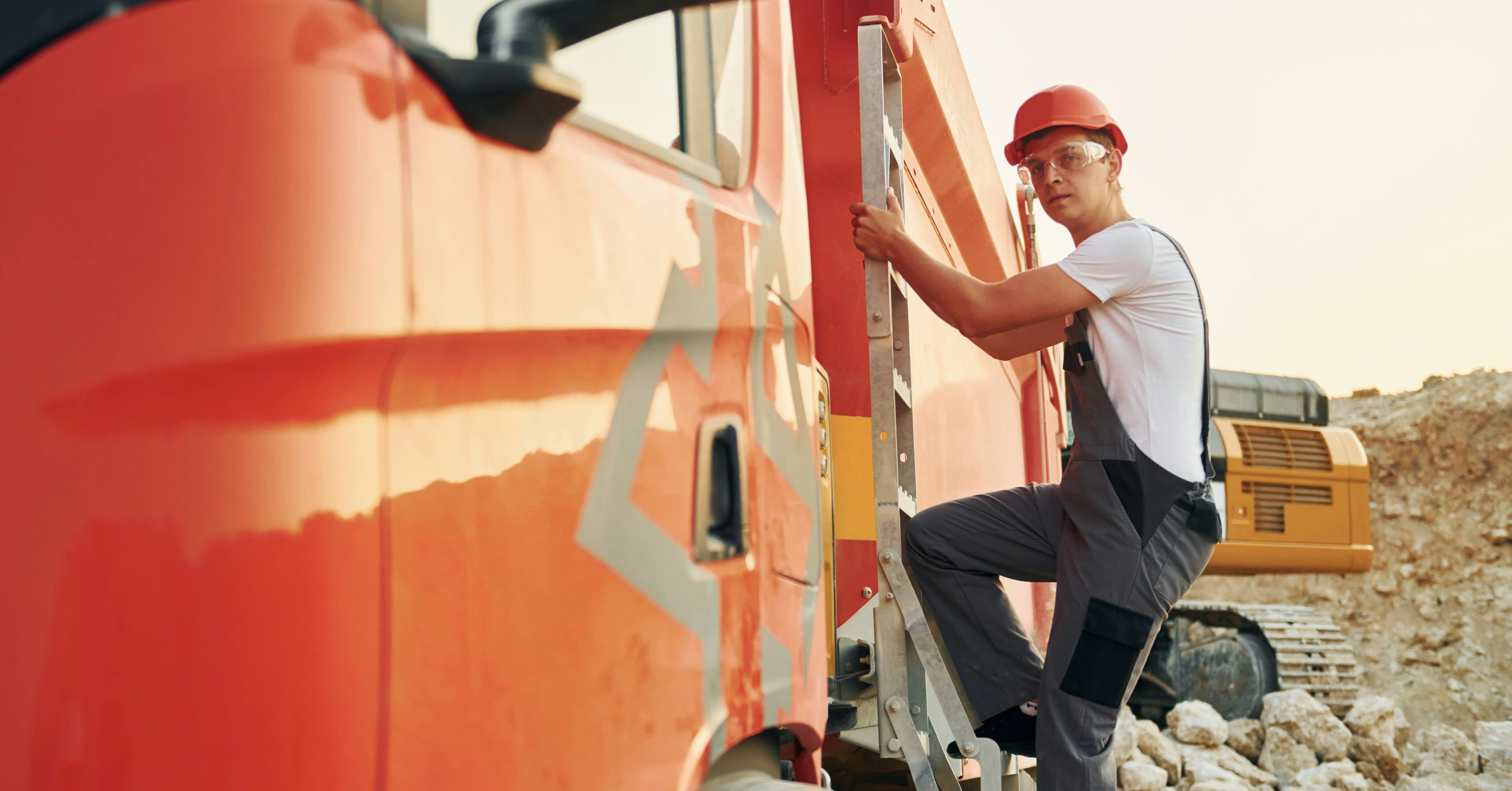 heavy equipment operator climbing into a truck